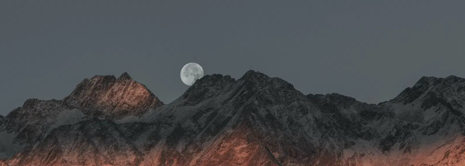 Mountain range with a moon in the sky